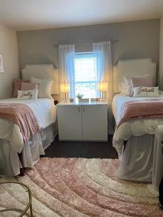 two beds in a bedroom with pink and white bedding