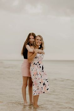 two women hugging each other on the beach