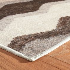 a close up view of a rug on the floor with wood floors and wooden furniture