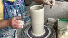 a man is making a vase out of clay on a potter's wheel with his hands