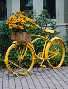 a yellow bicycle with flowers in the basket