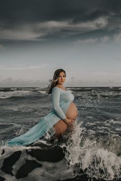 a pregnant woman is standing in the water