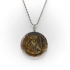 This is part of Chairish’s Fine Jewelry assortment.  This bronze coin, also known as a folis, is from the Byzantine Era. Byzantine coins are one of the most challenging and complex coins to identify.  This coin has an image of an emperor on the front; on the reverse is Arabic script, demonstrating that the embraces both the eastern and western worlds. The coin most likely dates to after the Arabs took over Constantinople, sometime after 900 AD.  The coin is surrounded by a hand hammered white go Byzantine Style Medallion Coin Necklace, Bronze Byzantine Round Jewelry, Handmade Antique Round Coin Necklace, Byzantine Yellow Gold Medallion Coin Necklace, Byzantine Coin Pendant Jewelry, Byzantine Round Coin Pendant Jewelry, Byzantine Style Yellow Gold Medallion Coin Necklace, Byzantine Medallion Coin Necklace In Yellow Gold, Byzantine Style Round Coin Pendant Jewelry