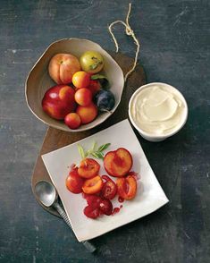 two bowls filled with fruit sitting on top of a table next to a bowl of yogurt