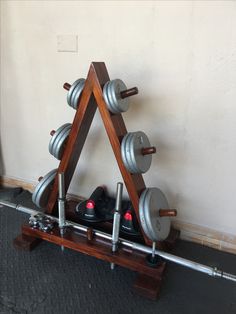 a wooden rack with three dumbs on it and two metal plates in the middle