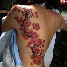 a woman's back with red flowers on it