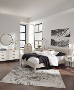 a bedroom with a bed, dressers, and mirror in it's center