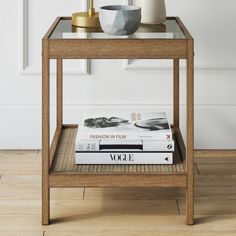 a table with some books on it and a vase sitting on top of the table