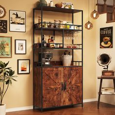 a wooden cabinet sitting in the corner of a room next to a wall with pictures on it