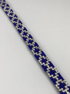 a blue and silver bracelet on a white surface