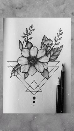 a black and white drawing of flowers in a geometric design on paper with a pen