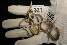 a pair of white gloves with key chains attached to the palm of a person's hand