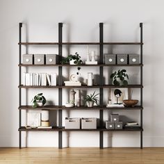 a book shelf filled with lots of books on top of a hard wood floor next to a white wall