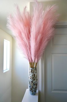 a vase with some pink feathers in it