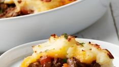 a close up of a plate of food with meat and cheese on it next to a bowl