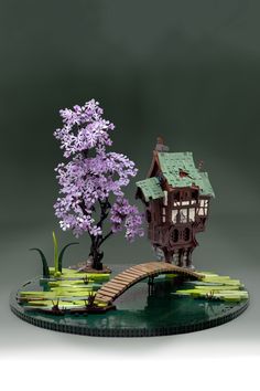 a miniature tree house on top of a pond with water lilies and a bridge