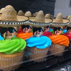 cupcakes decorated with hats and colored frosting are on display at a mexican themed party