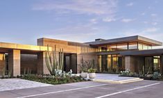 a modern house with cactus and succulents in the front yard