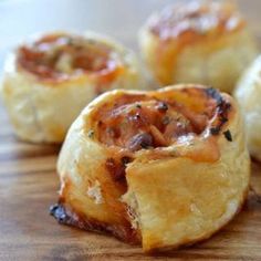 several small pastries sitting on top of a wooden cutting board