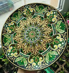 a decorative plate sitting on top of a window sill in front of a potted plant