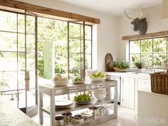 a kitchen filled with lots of counter top space and white cabinets next to an open window