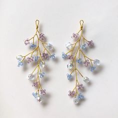 two pairs of earrings with blue, pink and white beads hanging from gold - plated hooks