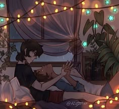 two people laying in bed with christmas lights on the ceiling