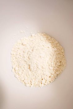 a white bowl filled with flour on top of a table