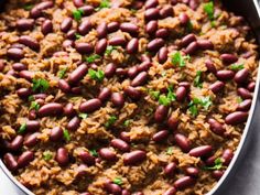 red beans and rice with parsley in a large pan on a white tablecloth