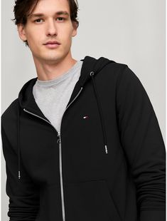 Tommy Hilfiger men's hoodie. Our classic zip hoodie is the perfect layering option for the changing seasons, but also works well on its own. It's made from heavyweight French terry cotton for breathability and comfort, and complete with rib-knit cuffs, collar and hem.  Material: 100% Regenerative Cotton. Tommy Hilfiger Hoodie With Drawstring Hood For Streetwear, Tommy Hilfiger Hooded Hoodie With Drawstring, Tommy Hilfiger Hoodie With Drawstring Hood, Tommy Hilfiger Cotton Hoodie Sweatshirt, Tommy Hilfiger Sporty Hoodie With Drawstring Hood, Tommy Hilfiger Sporty Hoodie With Ribbed Cuffs, Tommy Hilfiger Cotton Hoodie For Streetwear, Tommy Hilfiger Long Sleeve Cotton Hoodie, Tommy Hilfiger Casual Hoodie With Ribbed Cuffs