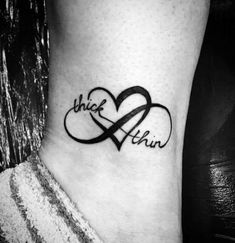 a black and white photo of a tattoo on the ankle with two hearts in it