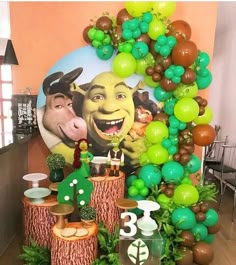 the balloon arch is decorated with green, brown and white balloons that resemble cartoon characters