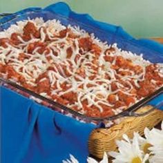 a casserole dish filled with meat and cheese covered in grated parmesan