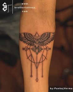 a tattoo on the leg of a person with a bird and arrow in its center