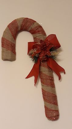 a candy cane decorated with red ribbon and bow