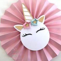 a pink paper fan with a unicorn face and gold glitter horn on it's head