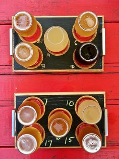 there are many different types of beer in the cups on this tray, and one is half empty