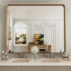 a bathroom with two sinks and a large mirror on the wall over it's sink