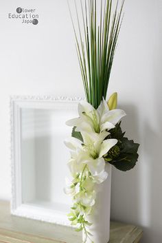 there is a vase with white flowers in it on the shelf next to a mirror