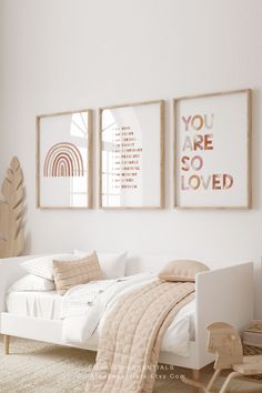 a white bedroom with three framed pictures on the wall