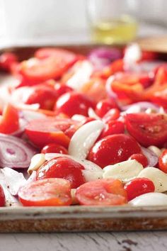 tomatoes, onions and garlic on a baking sheet