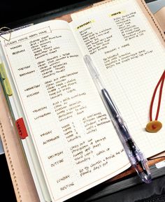 an open notebook with writing on it next to a pen and earbud holder