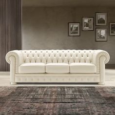 a white leather couch sitting on top of a rug