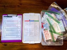 the contents of a medical kit laid out on top of a wooden table next to a clipboard