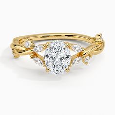 a yellow gold engagement ring with an oval cut diamond and leaves on the band, set in