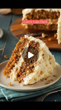 a piece of carrot cake with white frosting on a plate next to a knife and fork