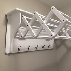 a white coat rack with four hooks on it