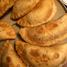 several empanadas sitting on a plate ready to be eaten