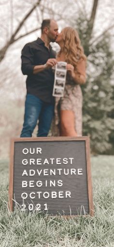 a man and woman standing next to each other near a sign