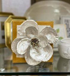 a white flower sitting on top of a glass table